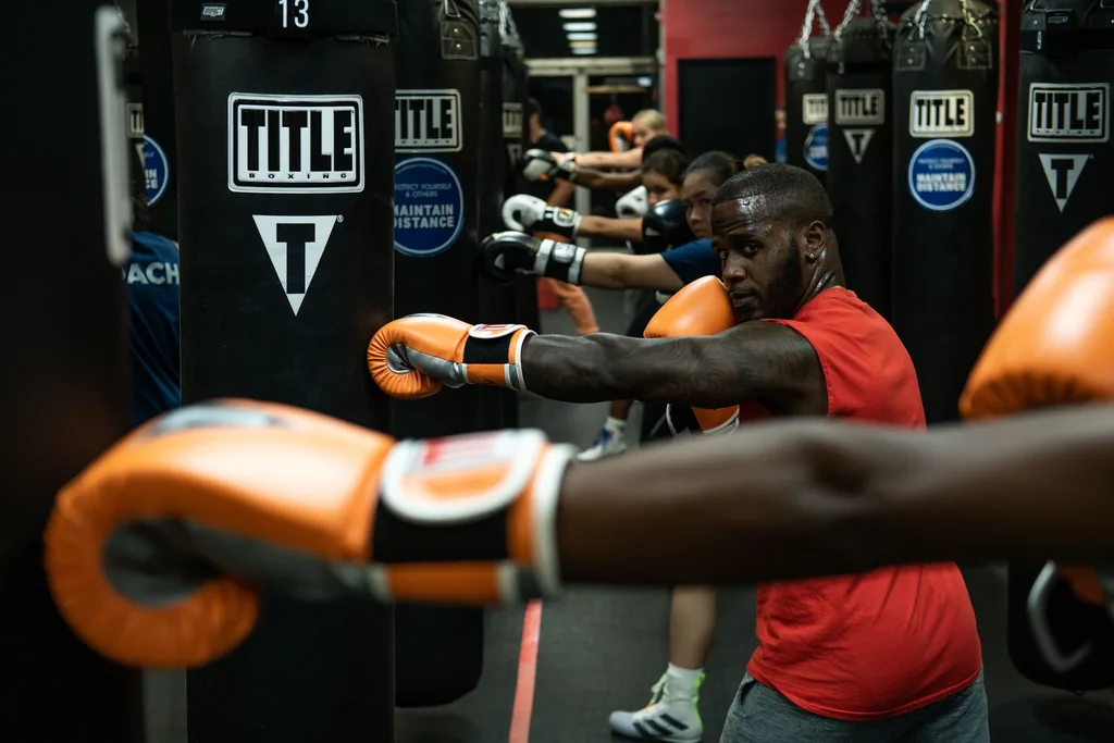 Grupo entrenando boxeo con sacos en una clase para empresas