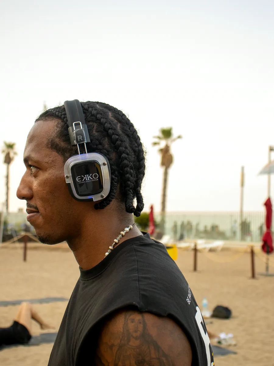 Participante con auriculares EKKO en la playa