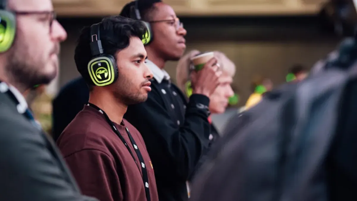 Asistentes a un evento de empresa escuchando con auriculares verdes