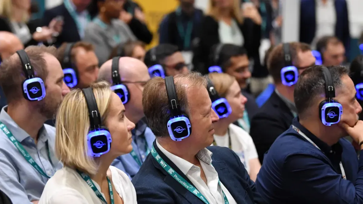Asistentes de congreso escuchando con auriculares multicanal