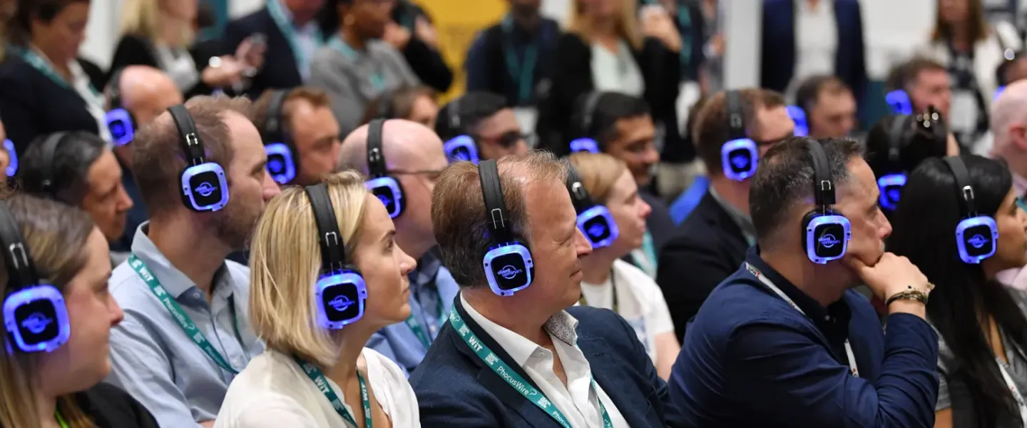 Asistentes de congreso escuchando con auriculares multicanal