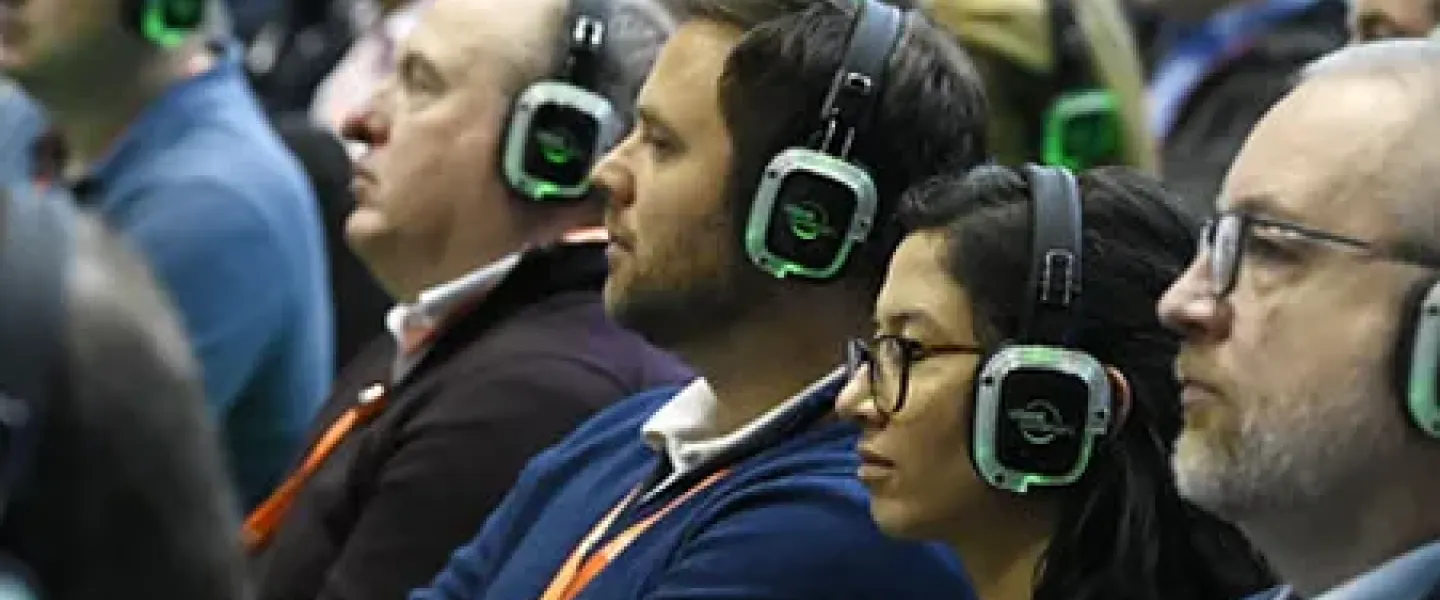 Directivos siguiendo una ponencia con auriculares inalámbricos