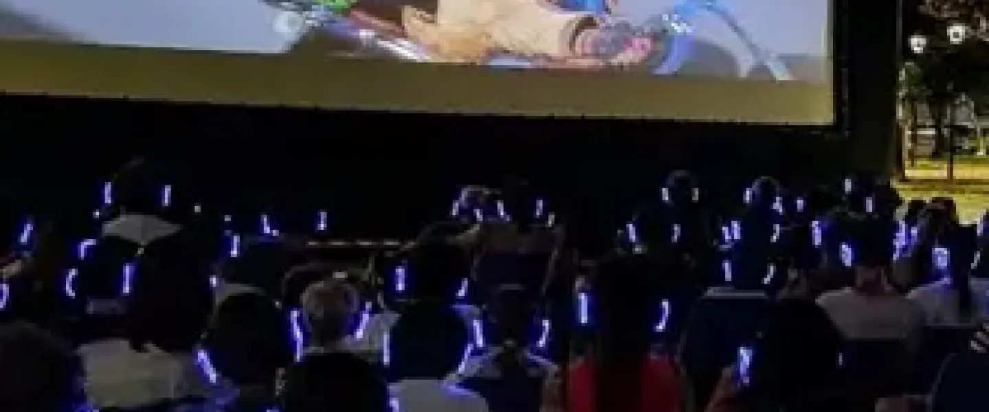 Cine al aire libre con público usando auriculares inalámbricos