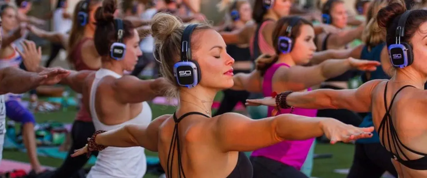 Clase colectiva de fitness con auriculares inalámbricos