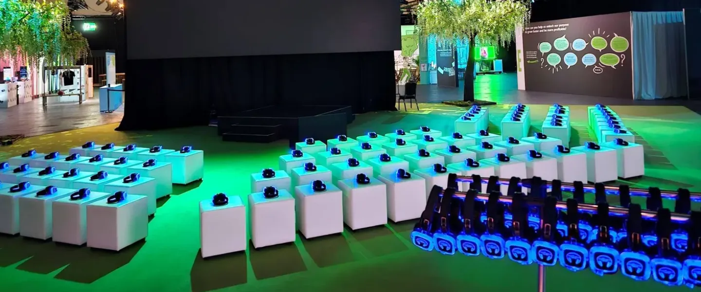 Escenario de evento corporativo con auriculares iluminados en verde