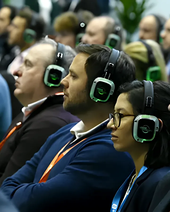 Directivos siguiendo una presentación con auriculares inalámbricos