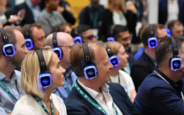 Asistentes de congreso escuchando con auriculares multicanal