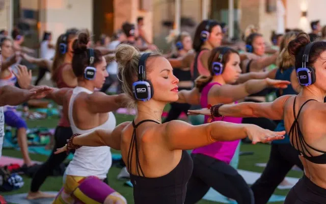Clase colectiva de fitness con auriculares inalámbricos