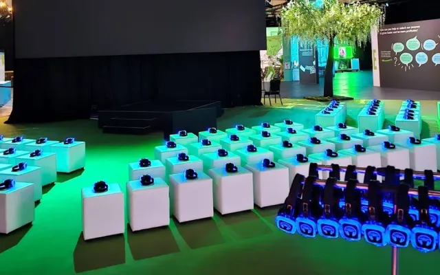 Escenario de evento corporativo con auriculares iluminados en verde