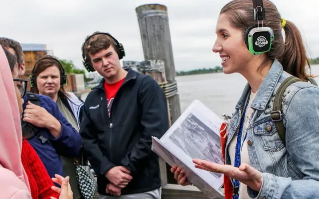 Guía turística explicando a un grupo con auriculares inalámbricos