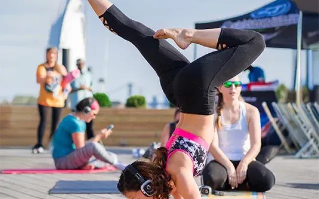 Práctica de yoga en terraza con auriculares silenciosos